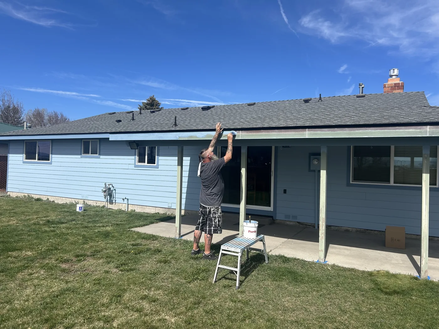 Linkville worker painting a customer home during an exterior project
