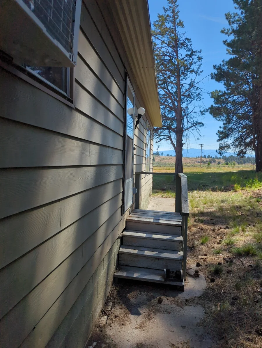 Before deck installation showing older entry steps and railing before a deck upgrade at a Klamath Falls home