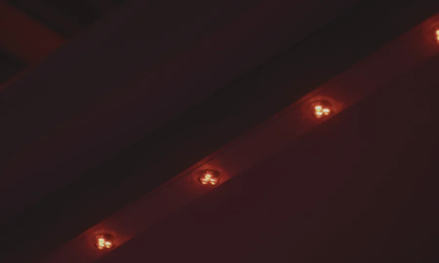 Close detail of red permanent outdoor lighting installed under an eave