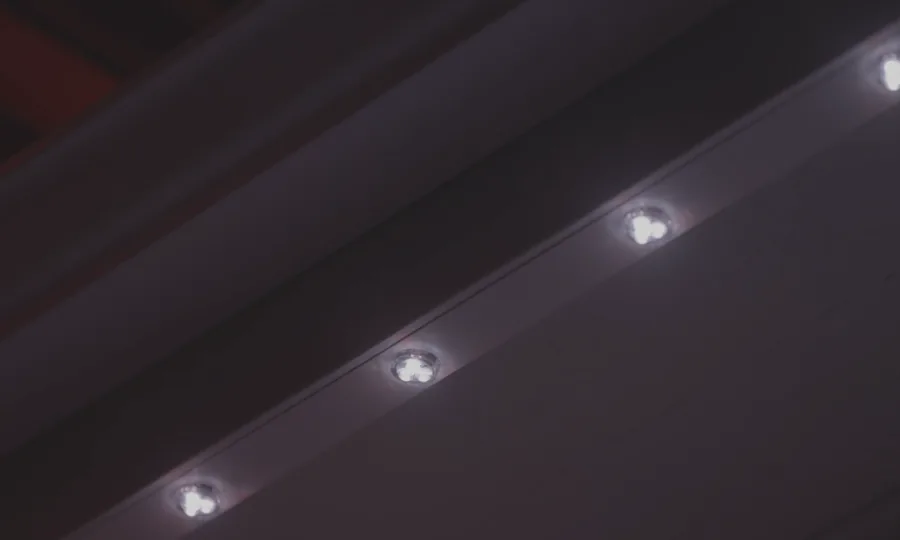 Close detail of white permanent outdoor lighting installed under an eave