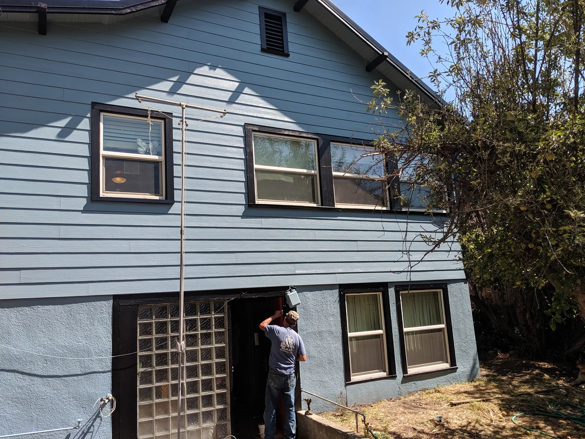 After siding replacement with blue lap siding and dark trim