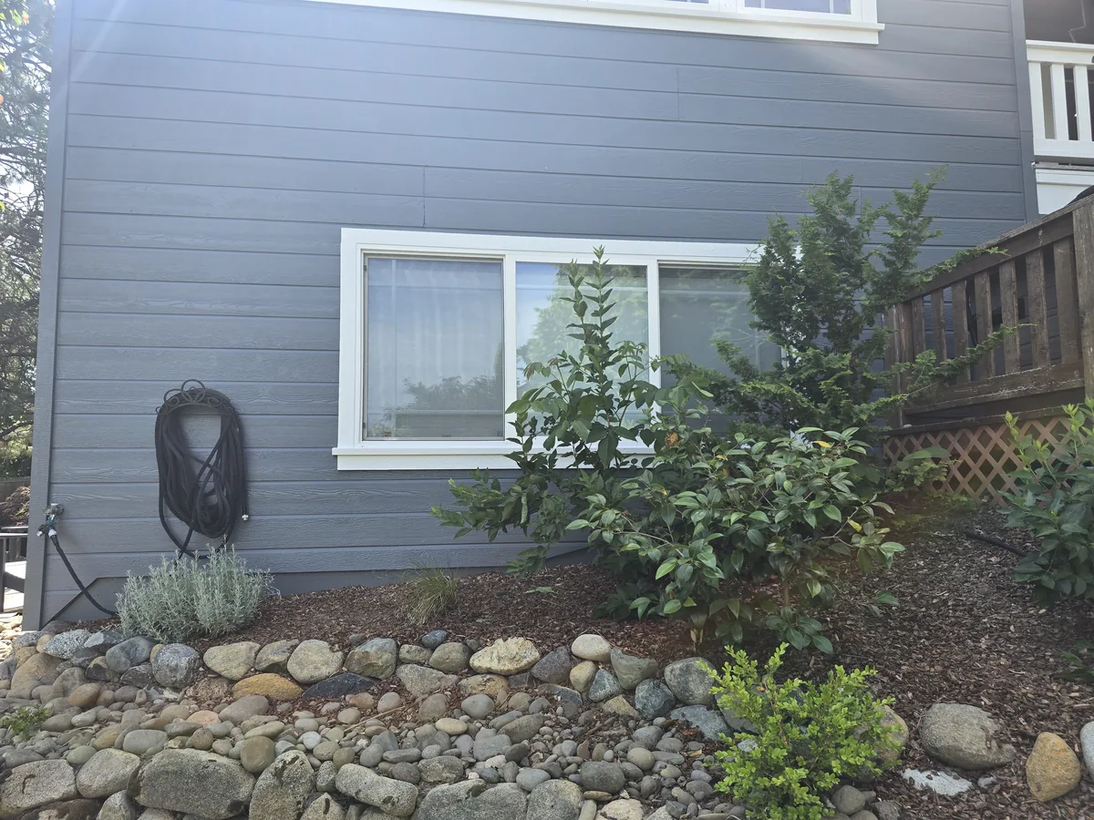 After siding repair with finished gray siding and window trim